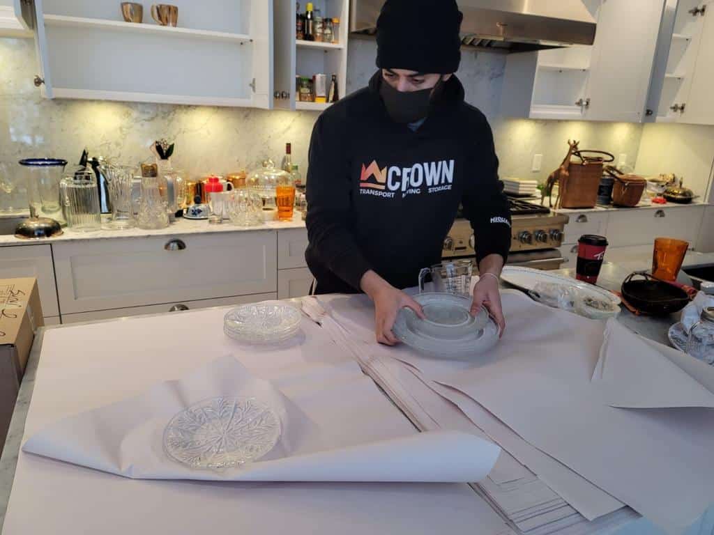 Crown Movers wrapping and packing kitchenware for a reliable moving service