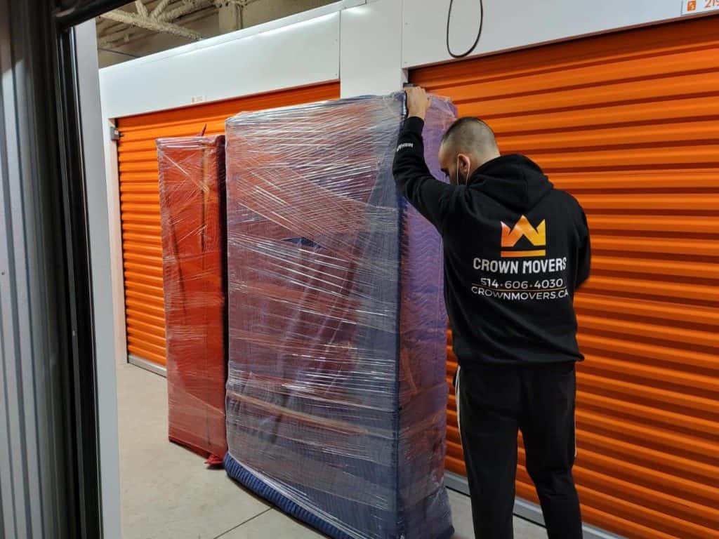 Crown Mover unloading wrapped furniture and putting it into a storage unit