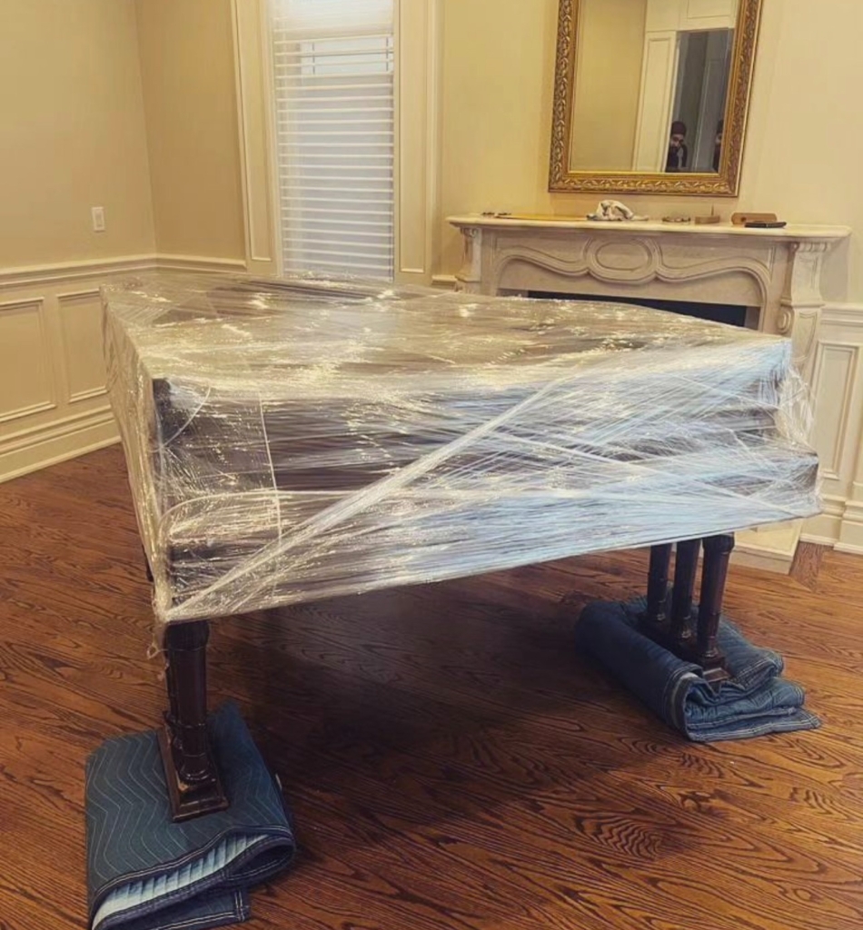 a piano wrapped carefully ready to be moved out of the house